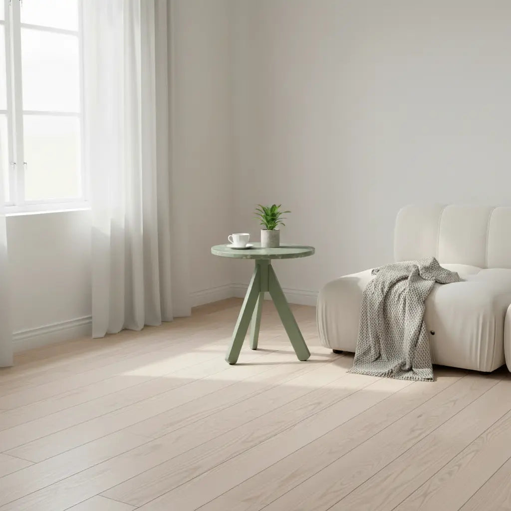 Sage green HDPE side table in a bright living room, next to a sofa with a knit throw and sheer window curtains